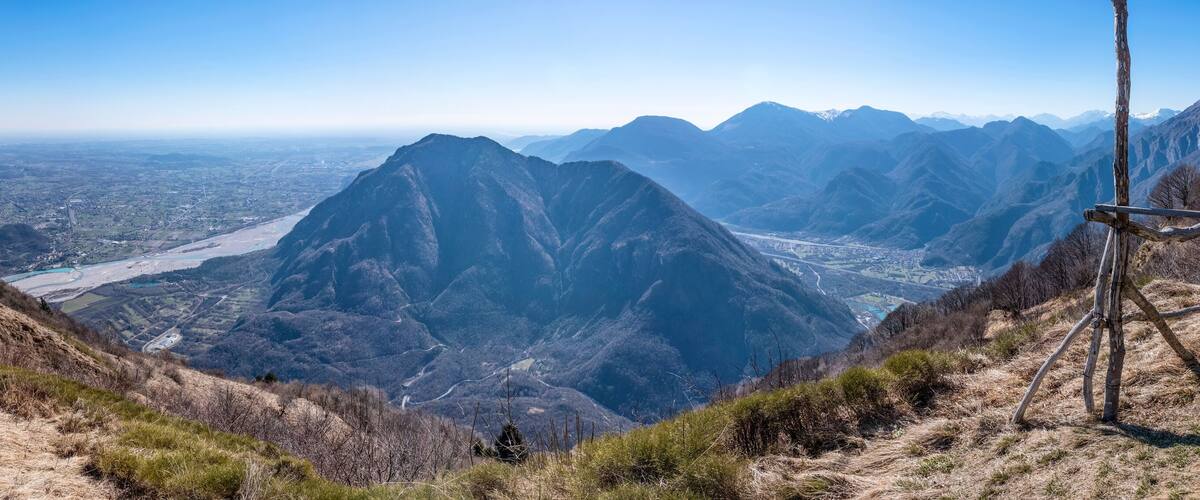 A mountainous landscape with a prominent peak, a winding road, and a valley below.