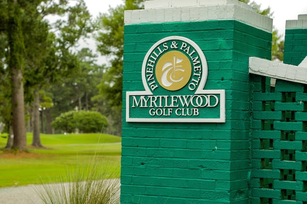 A green sign with the text "Pinnacles & Palmetto Golf Club" and "Myrtlewood Golf Club".