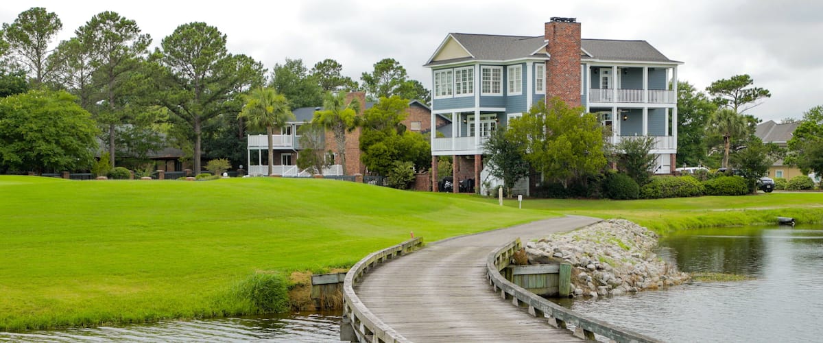Myrtlewood Golf Club featuring a bridge, a river or creek and a house