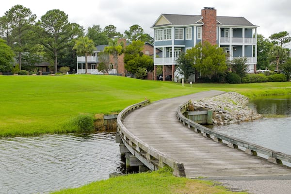 Myrtlewood Golf Club featuring a bridge, a river or creek and a house