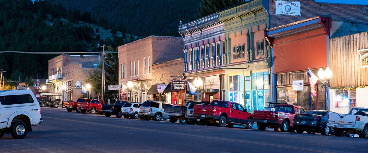 A street lined with historic buildings and parked cars.