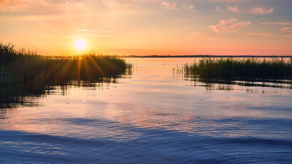 sunset over the lake Chiemsee in Germany (mosquitos over the water)