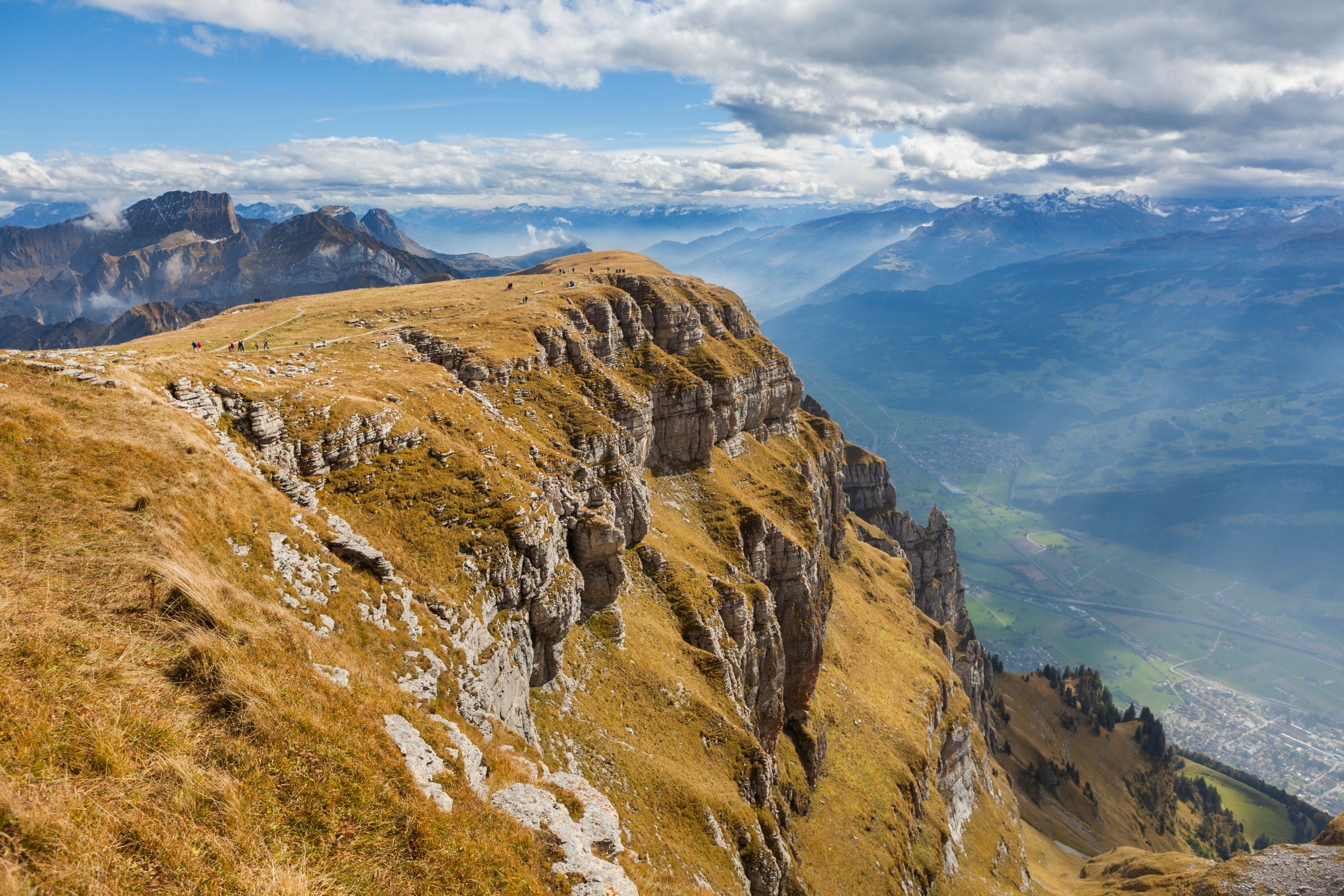 A mountainous landscape with a prominent rocky ridge and a valley below.
