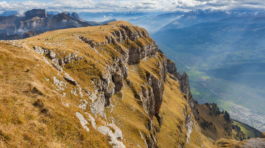 A mountainous landscape with a prominent rocky ridge and a valley below.