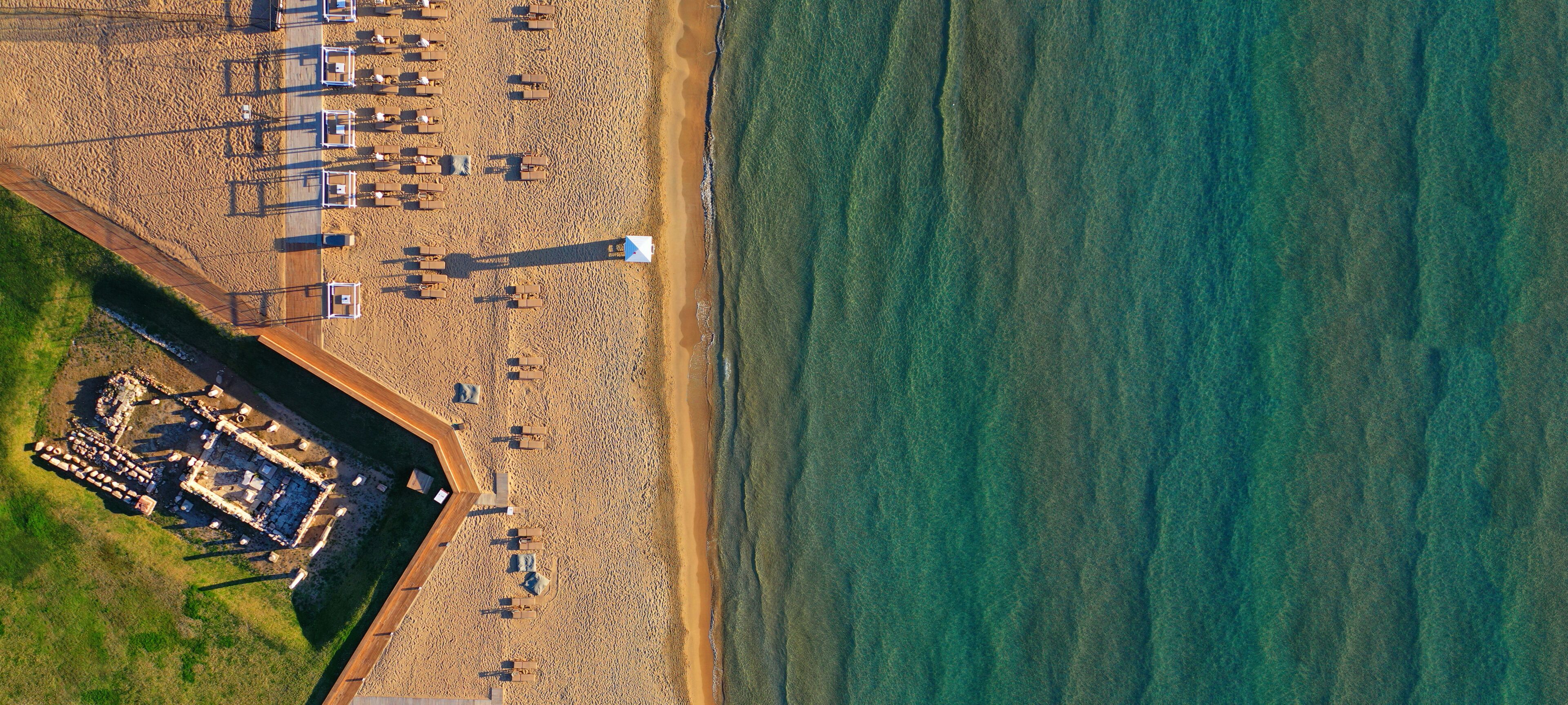 Aerial drone ultra wide top down photo of famous sandy beach of Asteras or Astir in Vouliagmeni, Glyfada, Athens riviera, Attica, Greece