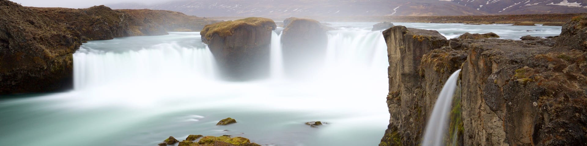 Godafoss which includes a cascade and mist or fog
