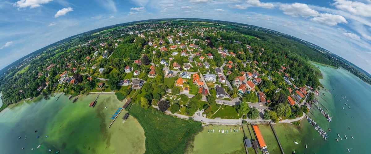 An aerial view of a coastal town with houses, a marina, and a large body of water.