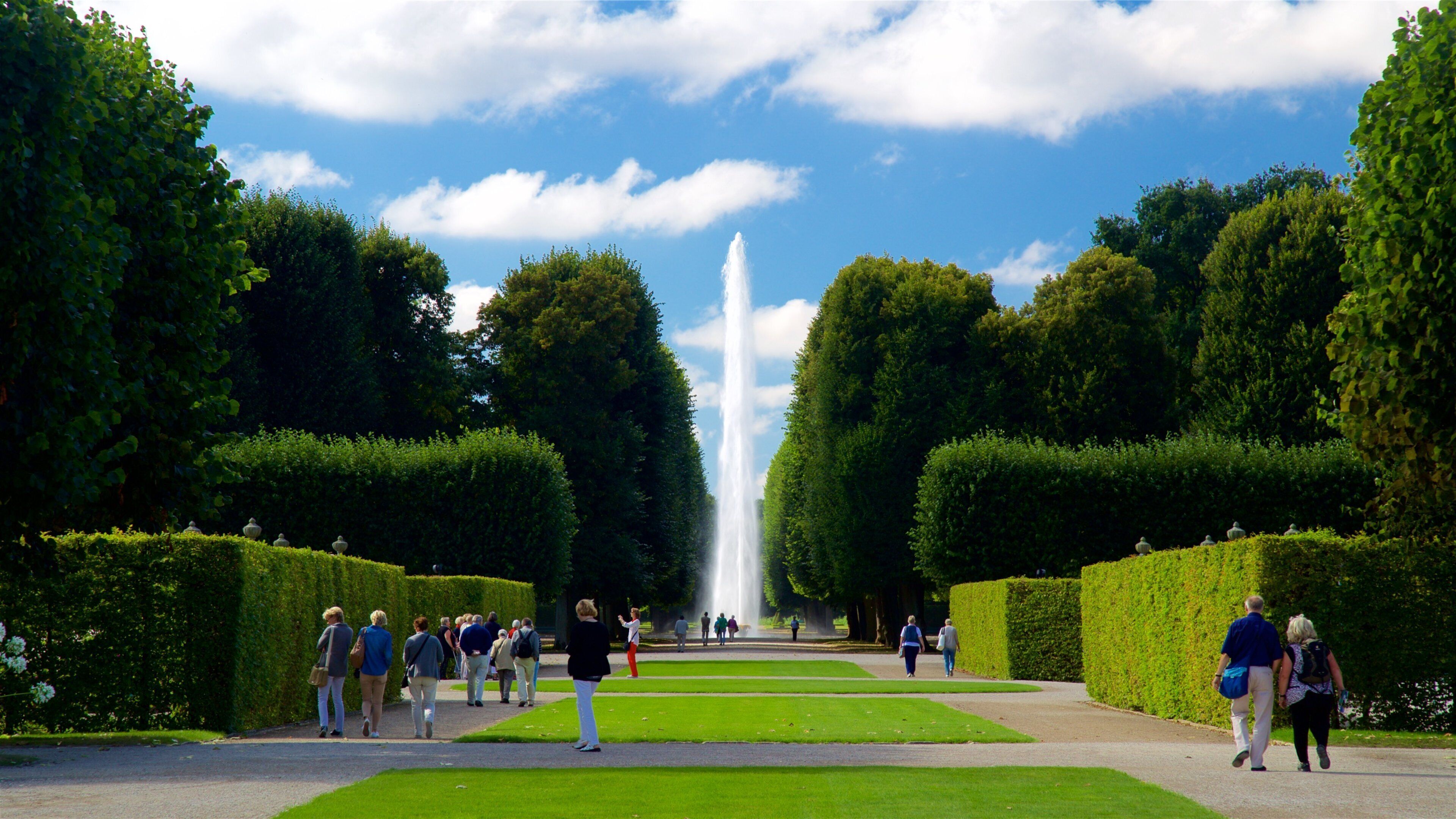 Herrenhäuser Gärten das einen Springbrunnen und Park sowie kleine Menschengruppe