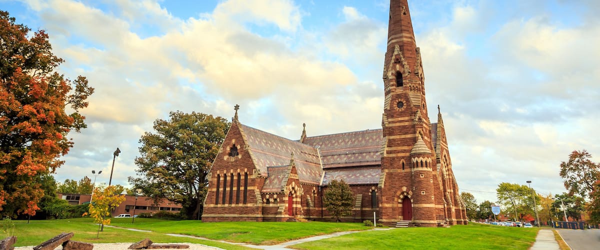 A large brick church with a tall steeple and a red door.