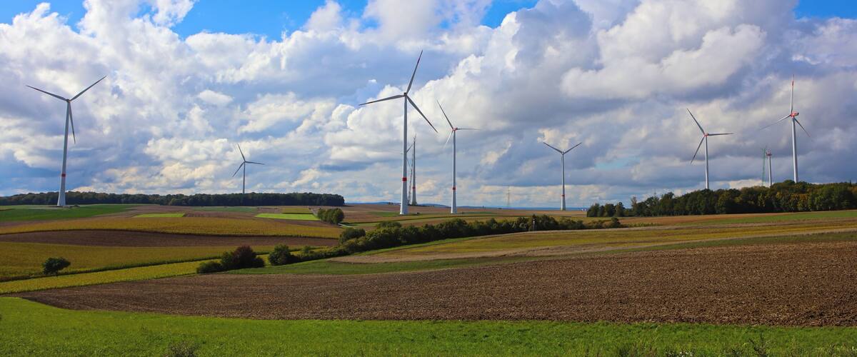 A landscape with wind turbines and fields under a partly cloudy sky.