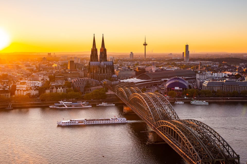 Ein Fluss mit einer Brücke, einer Stadtansicht und einem Boot.