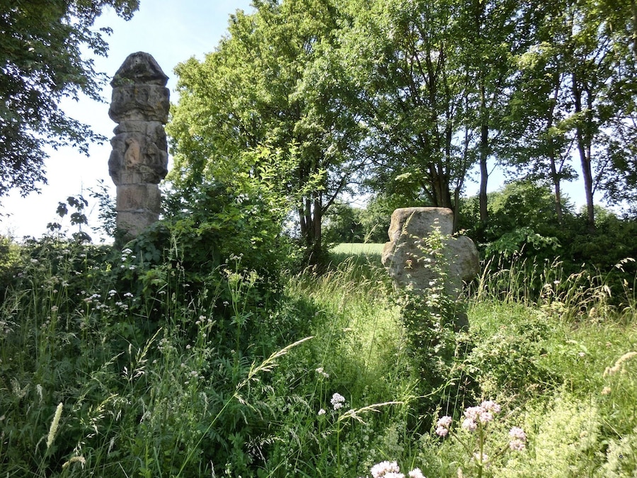 Un monumento de piedra rodeado de vegetación exuberante y árboles.
