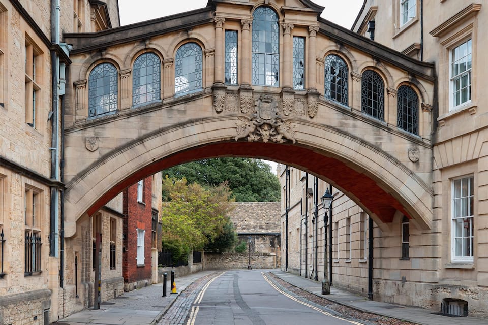 Uma ponte de pedra arqueada com detalhes ornamentados e janelas de vitrais.