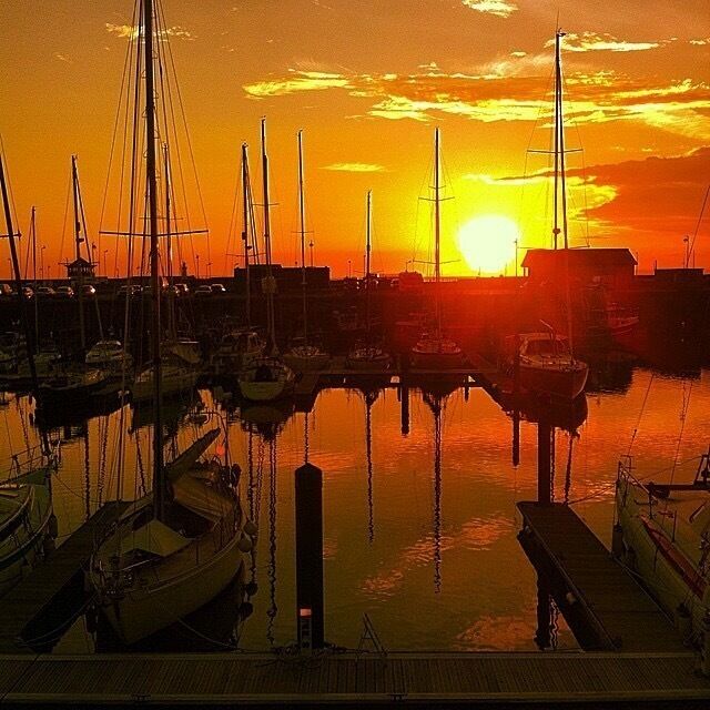 A marina with boats docked at sunset.