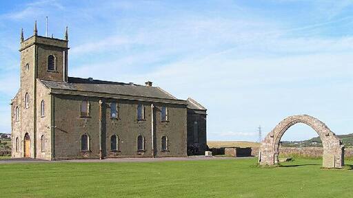St Bridget's, Moresby. The free-standing arch is a striking feature and the site itself is adjacent to a Roman milefort.