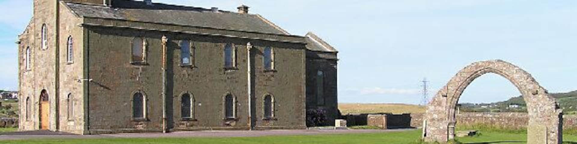 St Bridget's, Moresby. The free-standing arch is a striking feature and the site itself is adjacent to a Roman milefort.