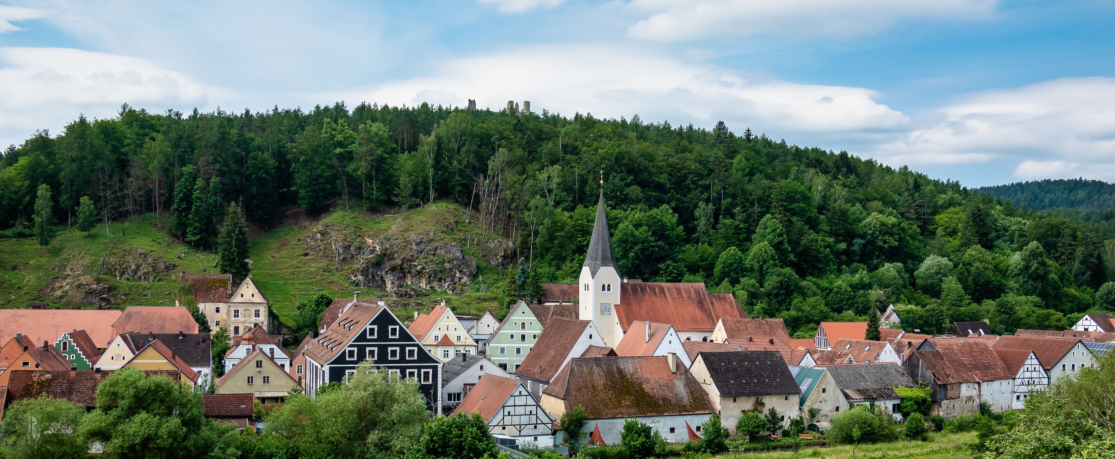 A village with traditional houses and a church on a hillside.