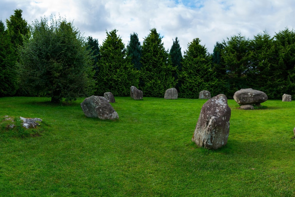 A grassy field with several large standing stones.