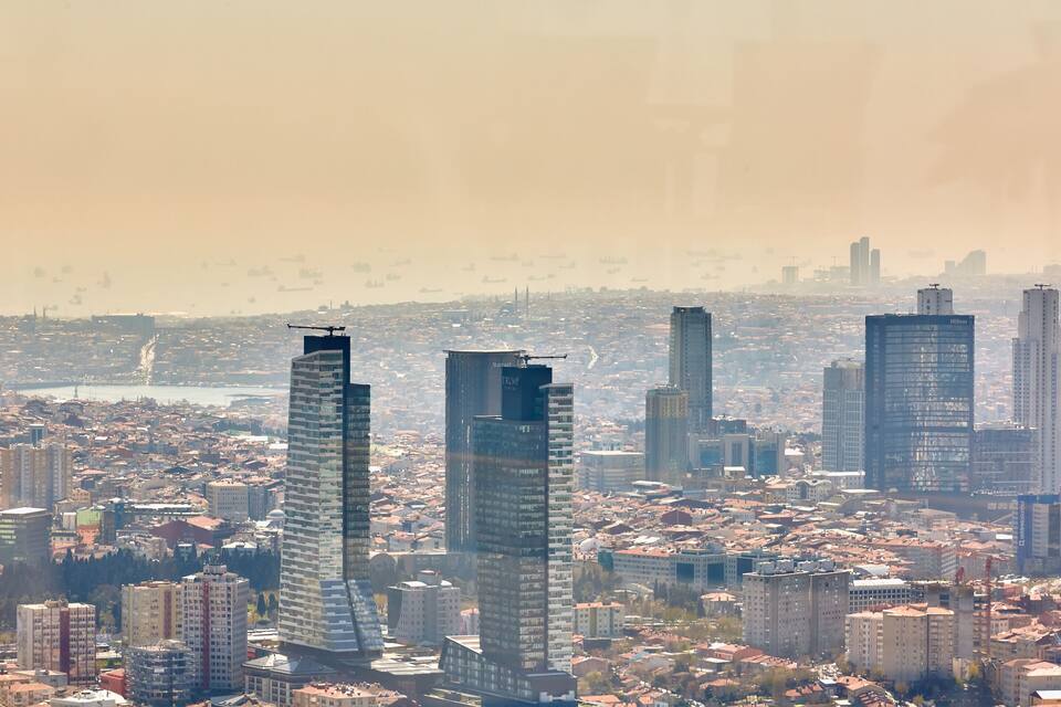 A cityscape with tall buildings, including a distinctive skyscraper with a unique design.
