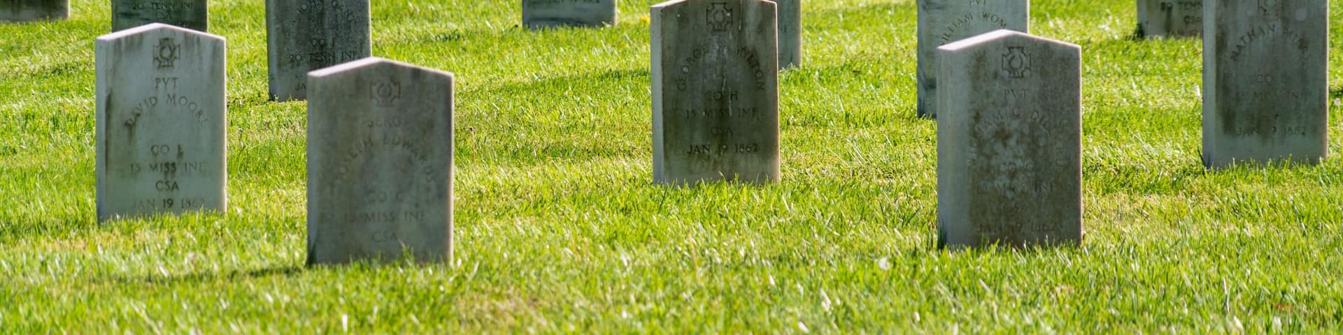 A cemetery with numerous headstones.