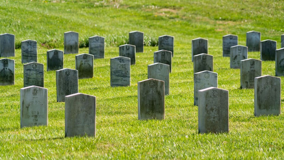 A cemetery with numerous headstones.