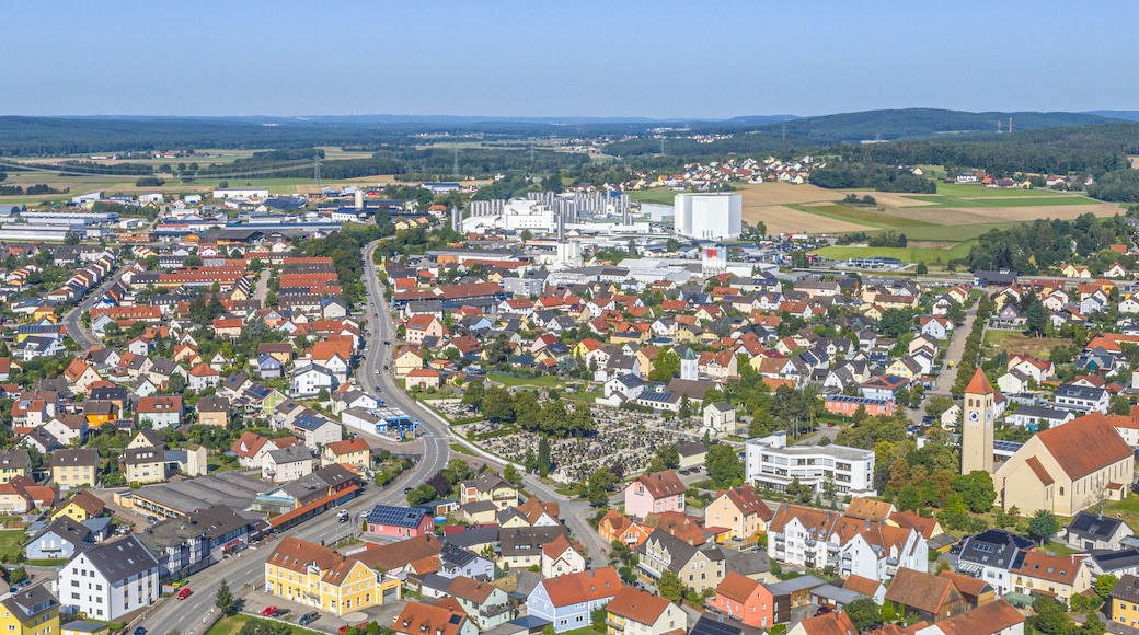 A town with a mix of residential houses, industrial buildings, and a prominent church tower.