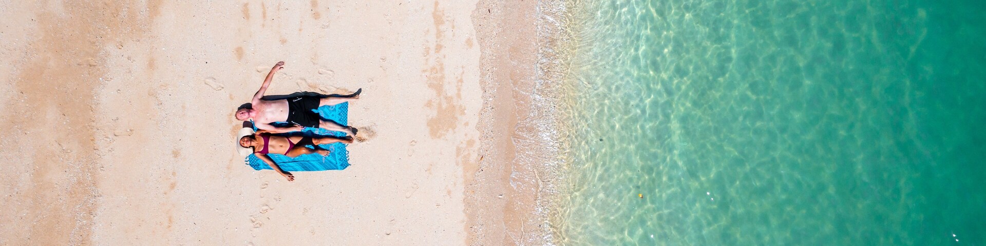 Una playa arenosa con agua turquesa cristalina.