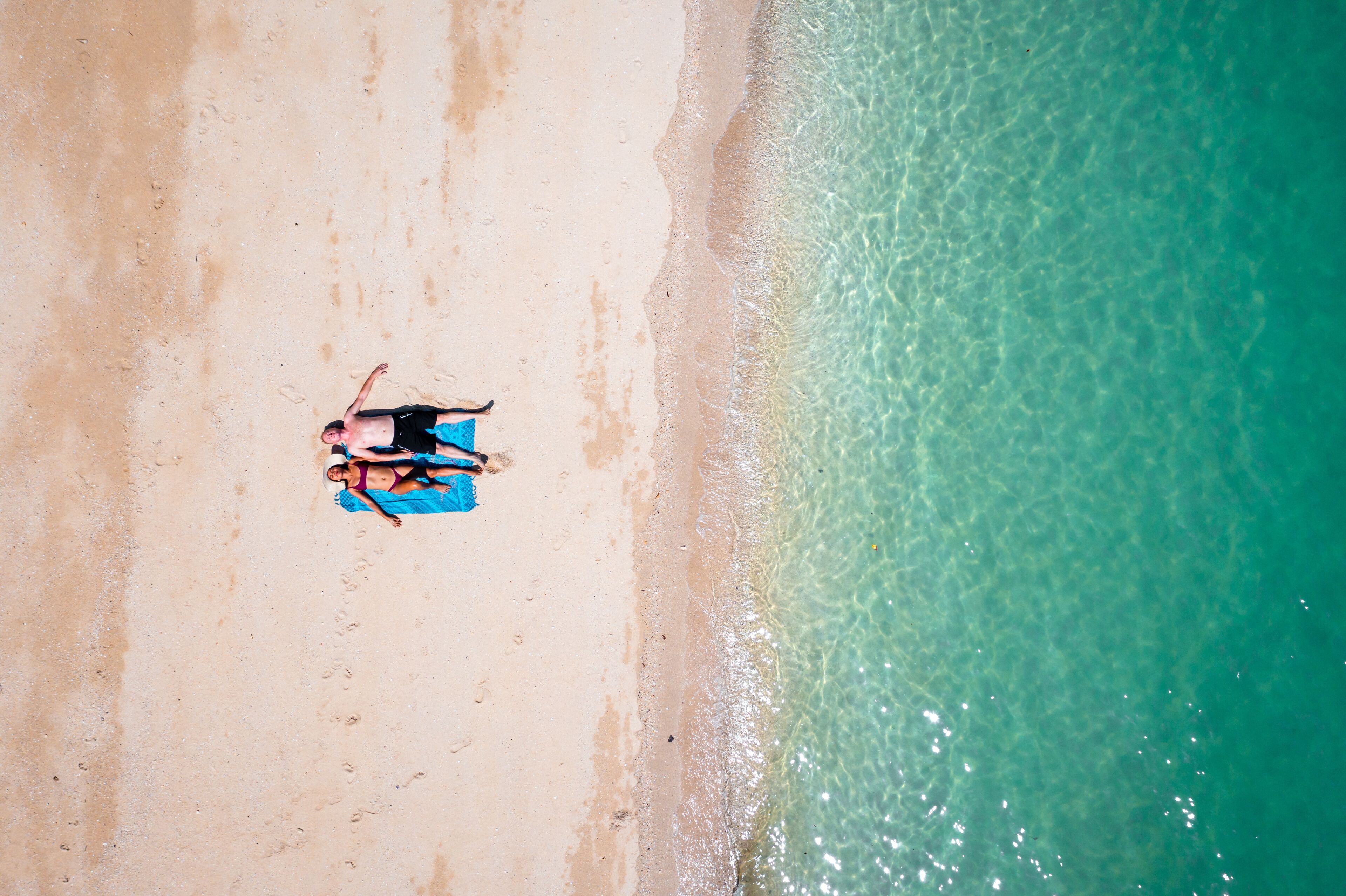 A sandy beach with clear turquoise water.