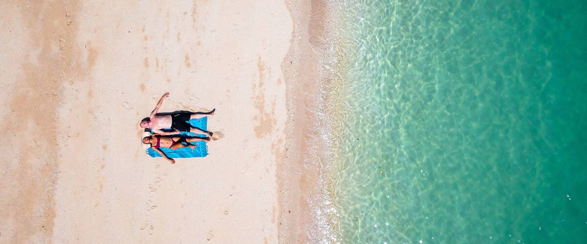 A sandy beach with clear turquoise water.