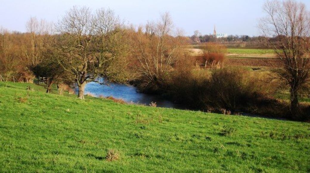 View towards Cambridge View of the River Cam as it flows into Cambridge. The tall spire in the background belongs to the Roman Catholic church on the corner of Lensfield Road and Regent Street. This corner is also known as Hyde Park corner. The farmland is part of the Trumpington Hall Estate.