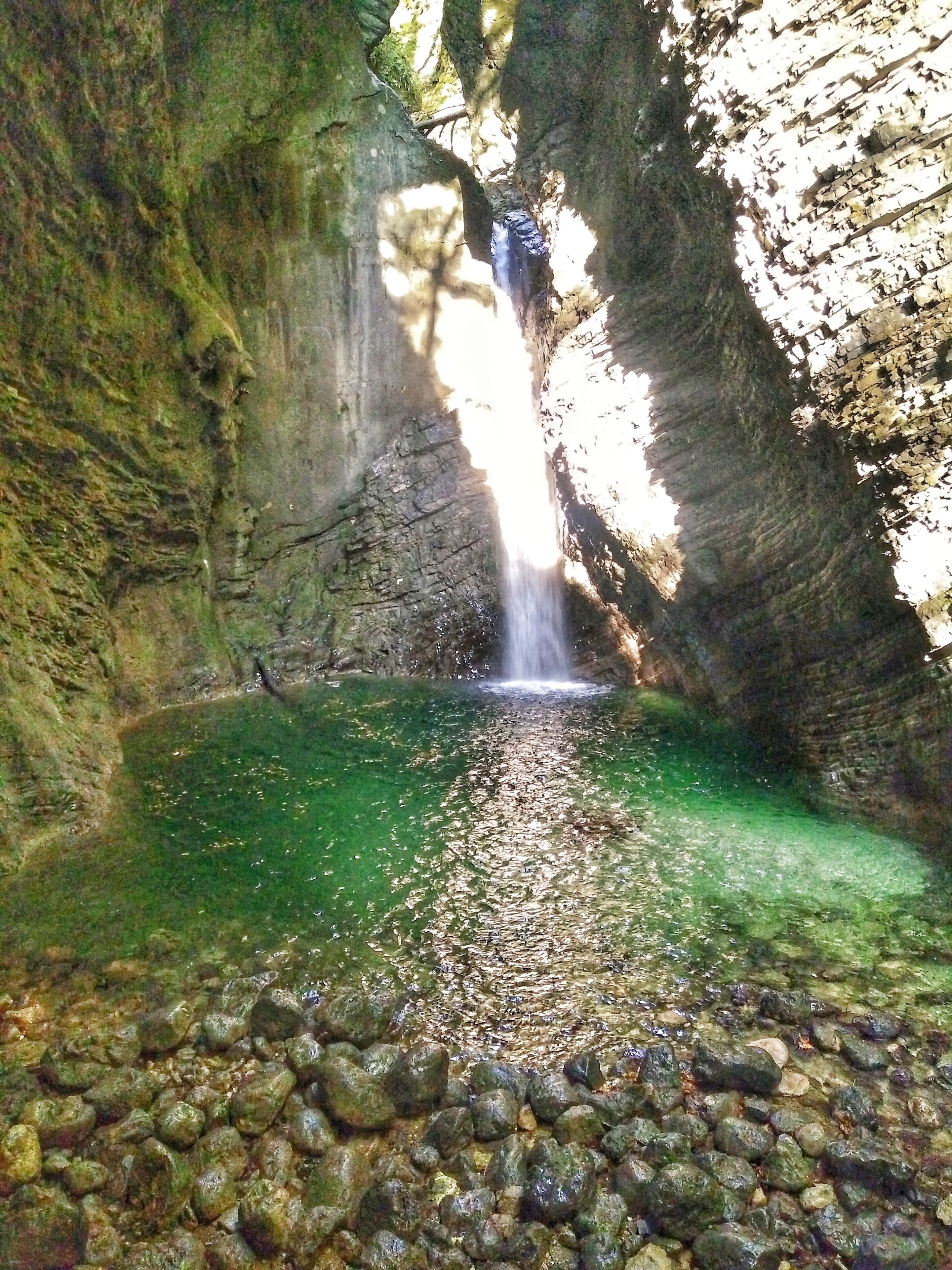 Kozjak is a hidden waterfall that falls from the 'roof' of a cracked-open cave into emerald deep pool before leaving the alcove. Walk through Soča river, cross wooden small bridges and climb along wooden boardwalk in order to reach the waterfall.