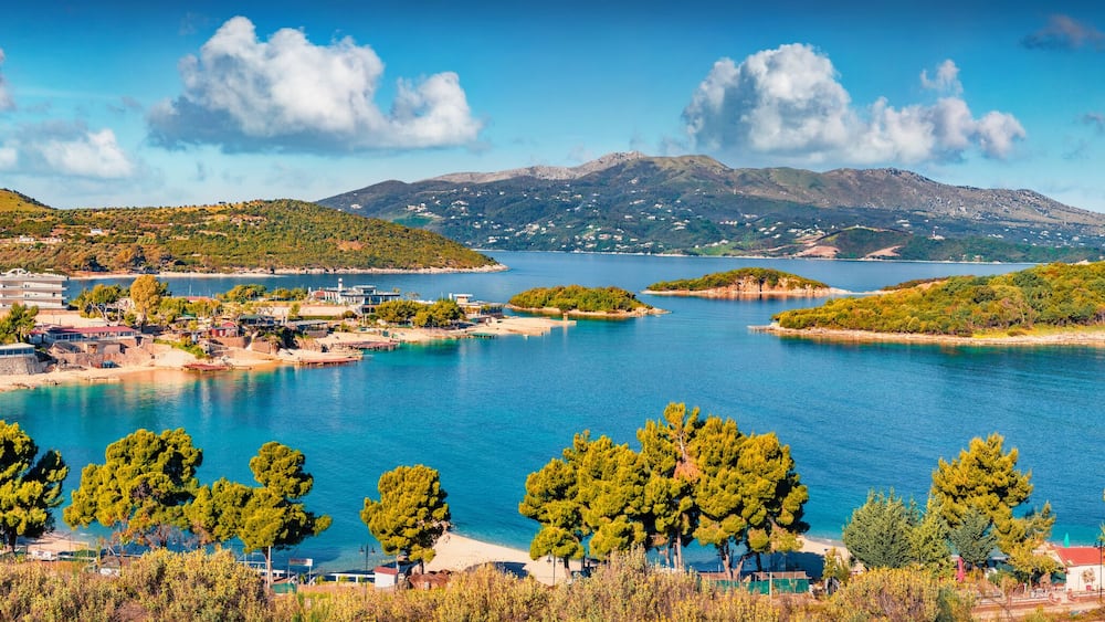 Panoramic seascape of Ionian sea with Corfu island on background. Wonderful spring view of Ksamil village. Spectacular outdoor scene of Albania, Europe. Traveling concept background.
