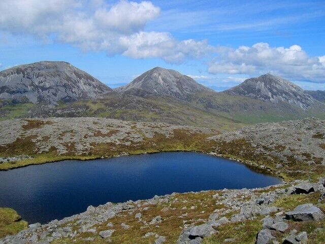 A mountain landscape with a small lake surrounded by rocky terrain.
