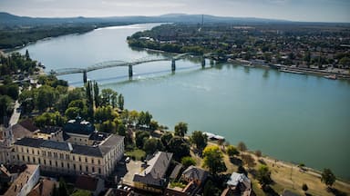 A river with a bridge, buildings, and trees.
