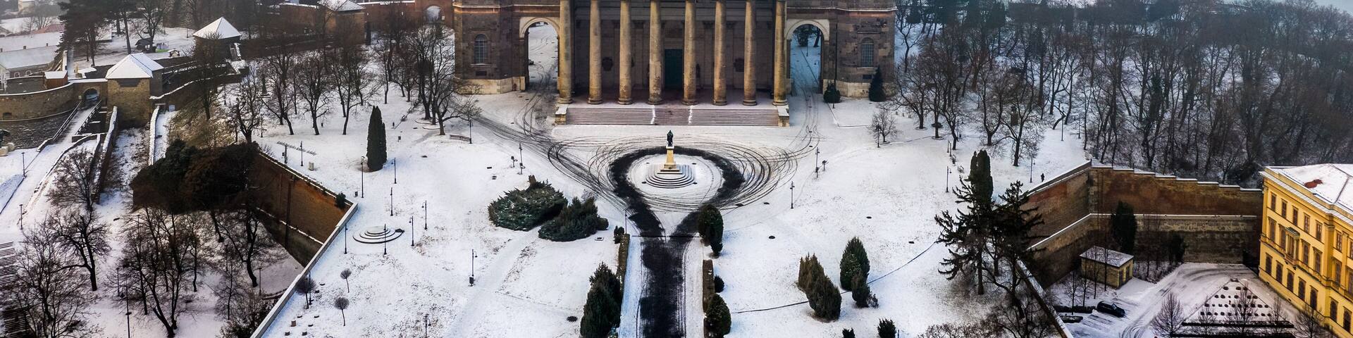 Esztergom, Hungary - Aerial view of the beautiful snowy Basilica of Esztergom with Slovakia at the background on a foggy winter morning