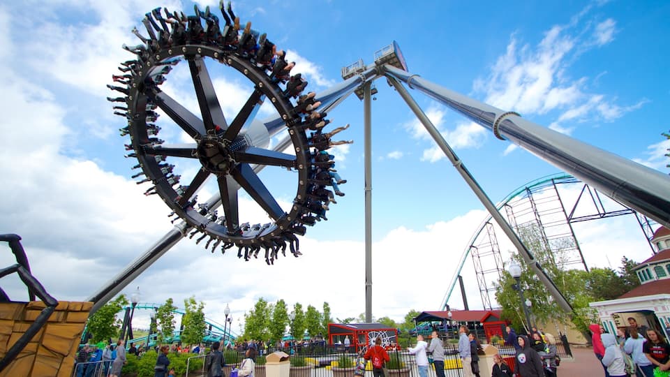 A large amusement park ride with a circular motion, a Ferris wheel, and a crowd of people.