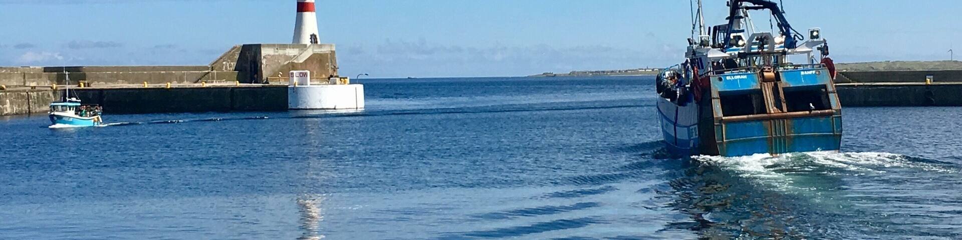 Fishing boats coming and going at Fraserburgh Harbour Scotland
