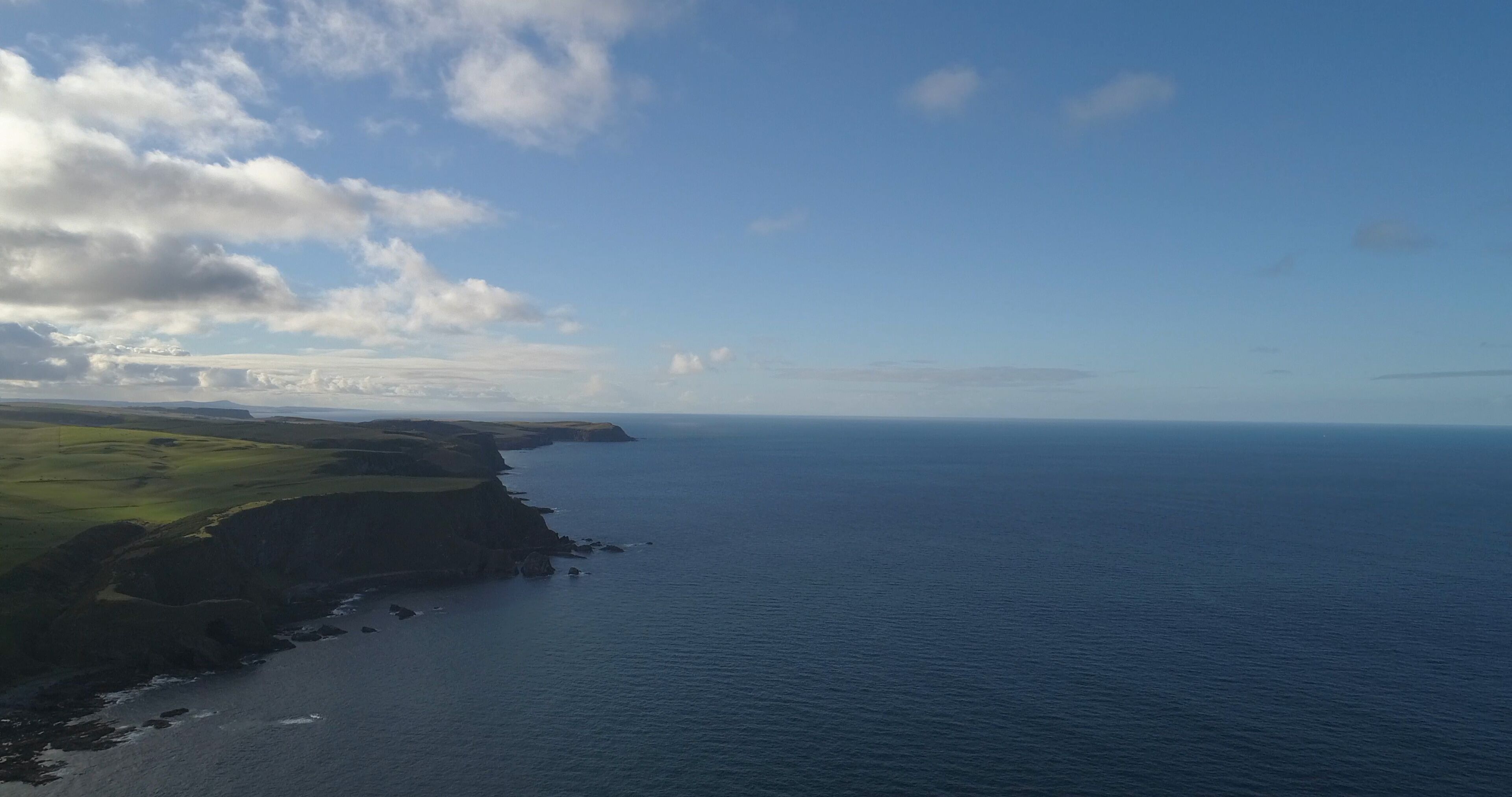 A coastal landscape with cliffs and a view of the ocean.