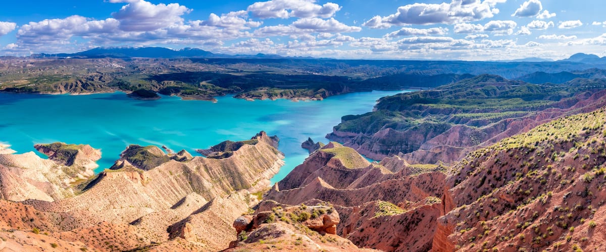 A canyon with turquoise lakes and rugged terrain.