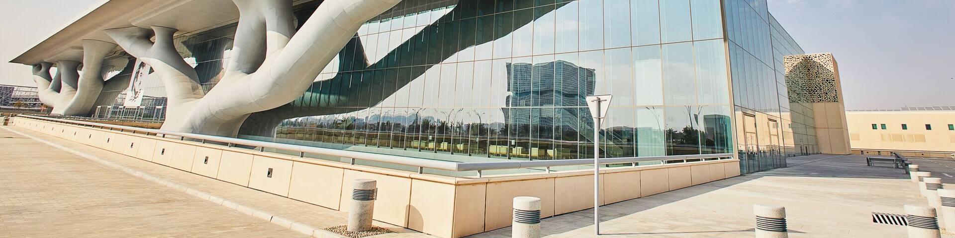 A modern building with a unique architectural design featuring large, tree-like structures supporting a slanted roof.