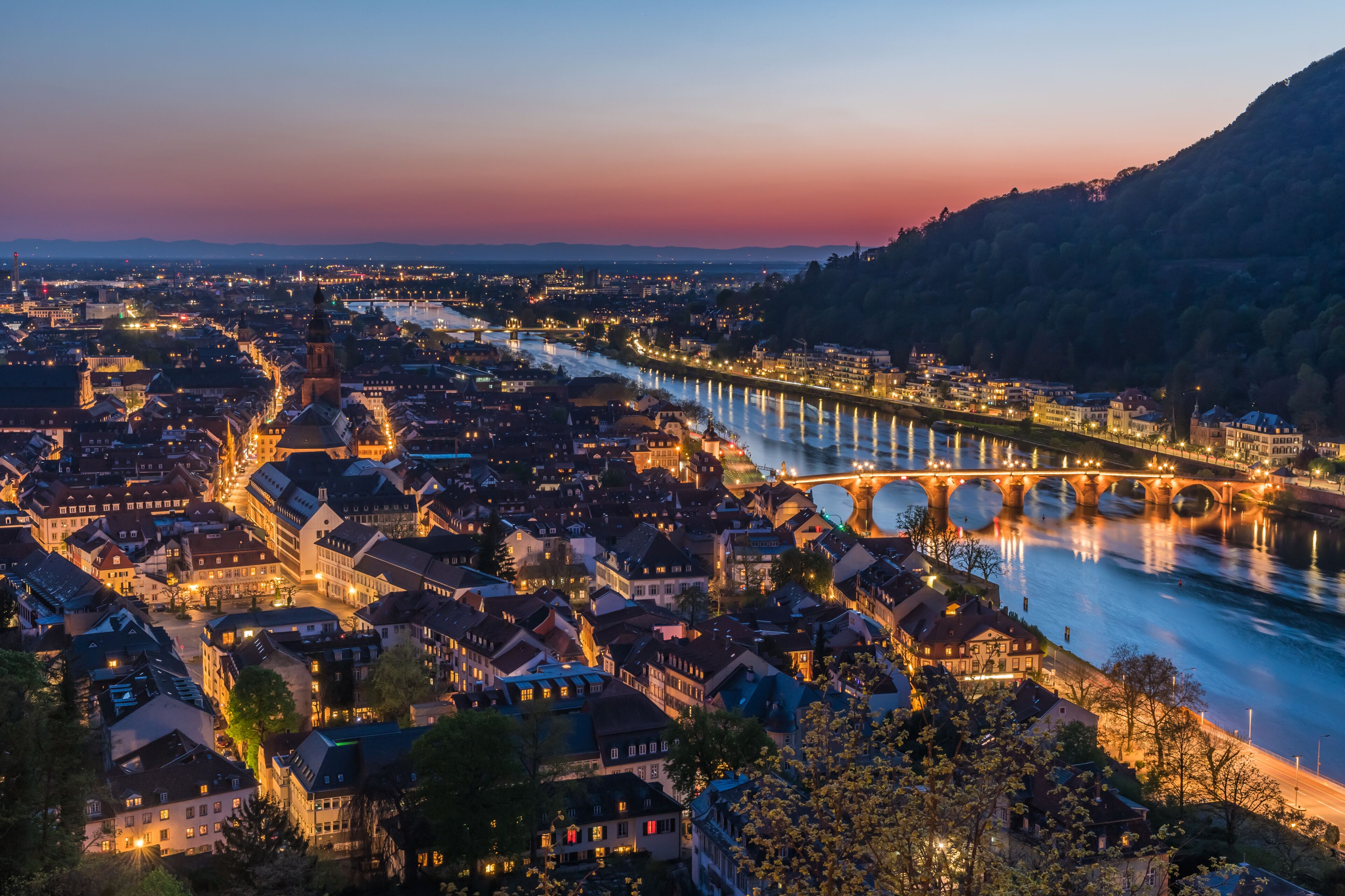 Heidelberg panorama with old city, old bridge and Neckar river after sunset. Beautiful illuminated.