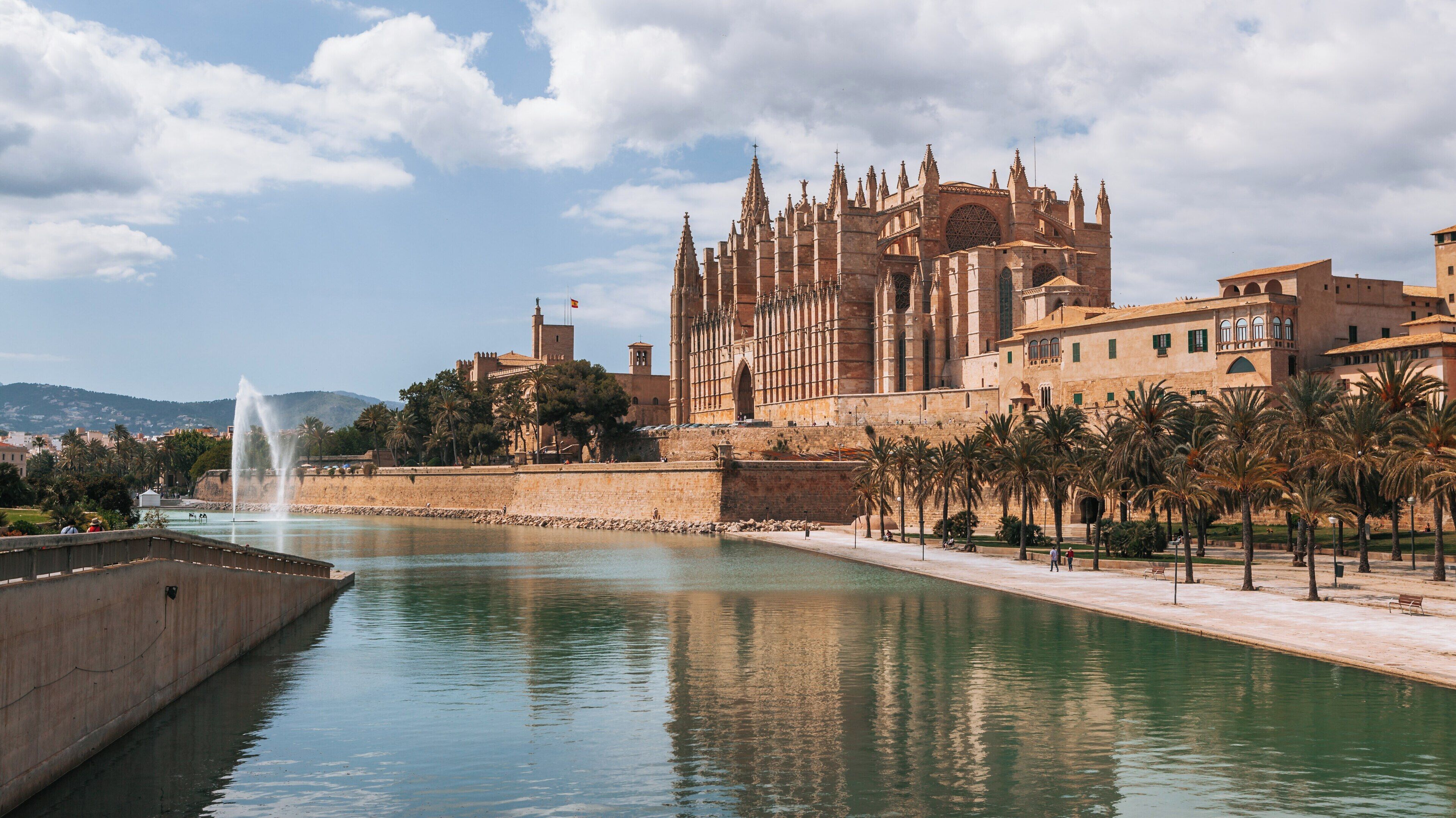 Beautiful waterside view of Parc de la Mar in Palma de Mallorca showcasing the stunning architecture of the cathedral and surrounding buildings under a bright sky