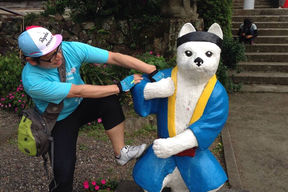 A person painting a statue of a bear in traditional attire.