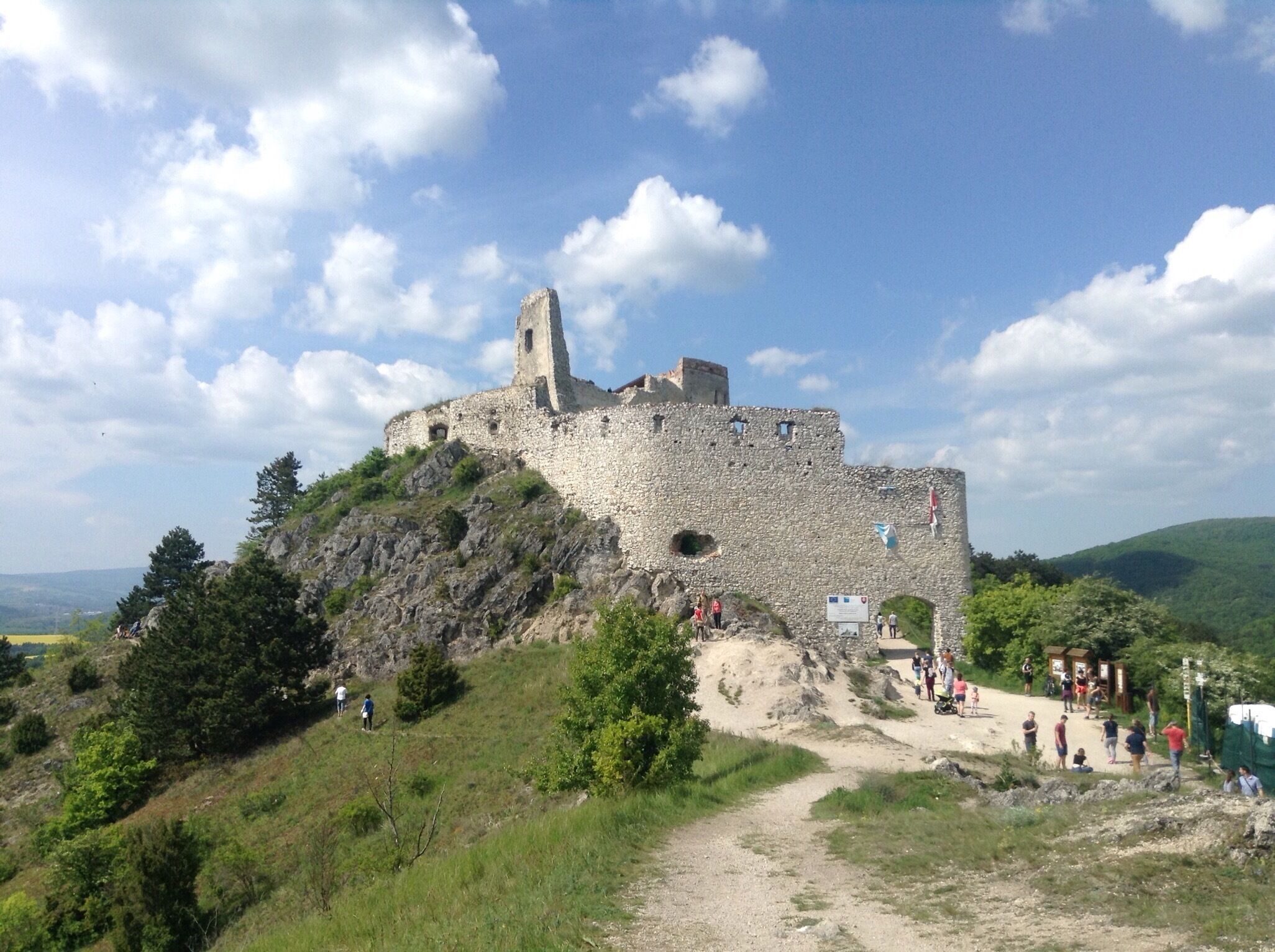 A historic stone castle on a hill with a clear sky.