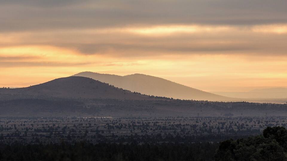 A mountain range with a valley in the foreground.