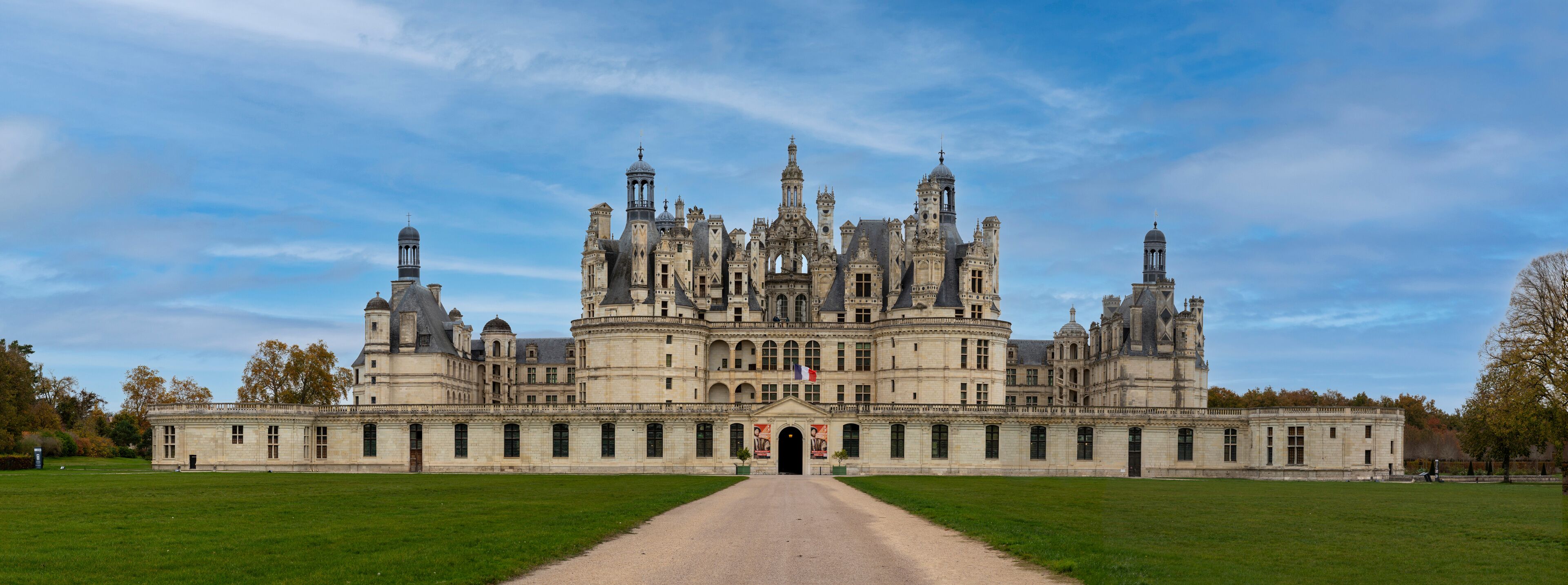 Chambord, France - 10 27 2025: Panoramic view of the Chambord Castle building with main entrance, balconies, tower of the double helix staircase, towers, bell towers and chimneys
