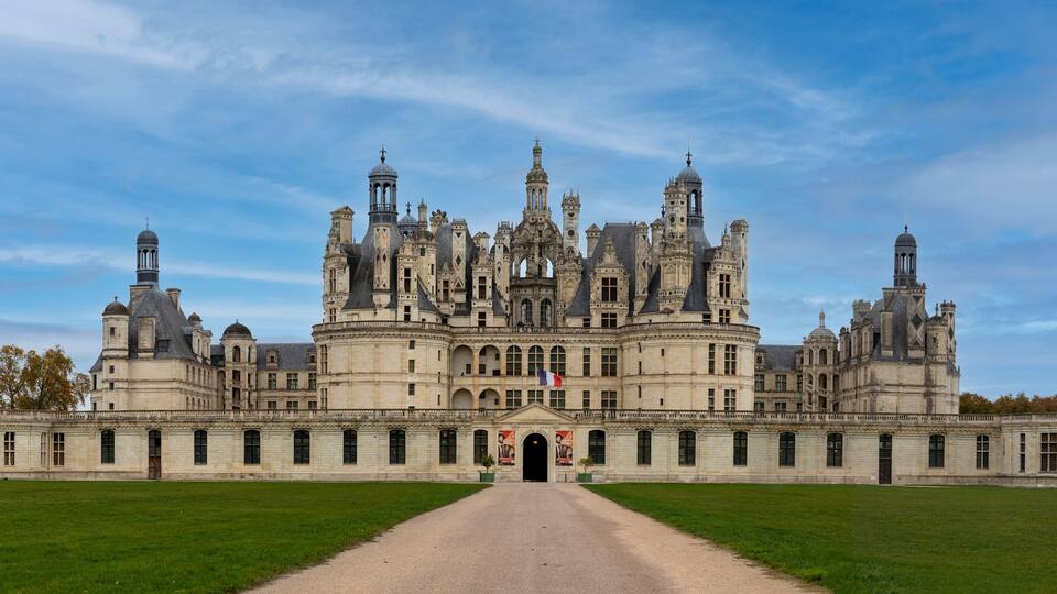 A grand, historic building with multiple towers and a central entrance.