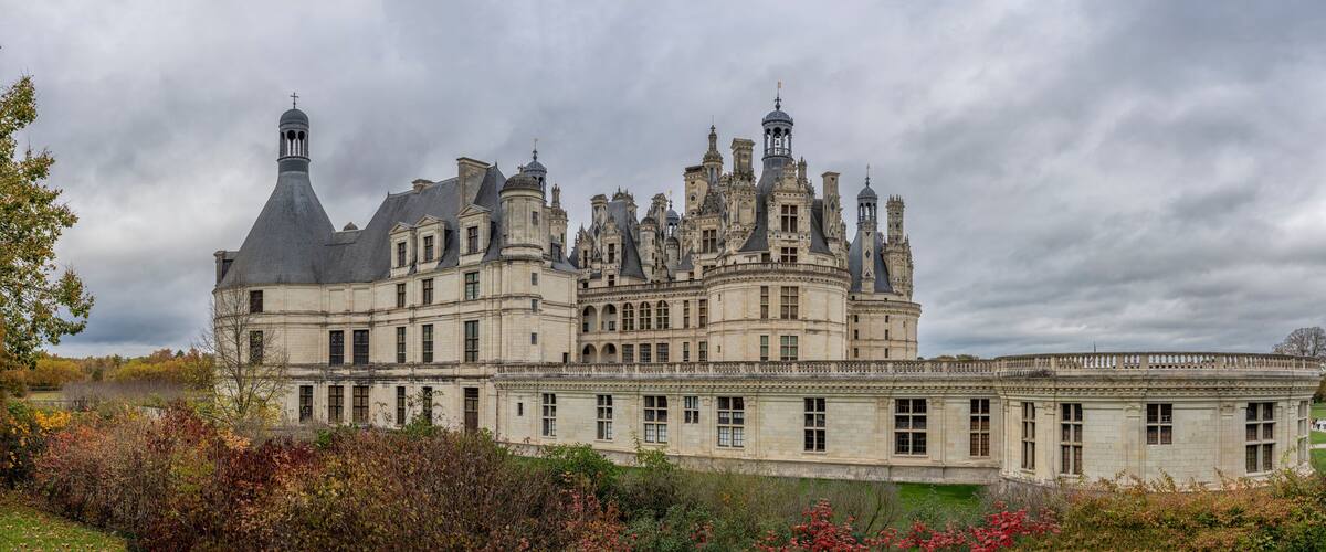 A large, ornate castle with multiple towers and a well-maintained garden.