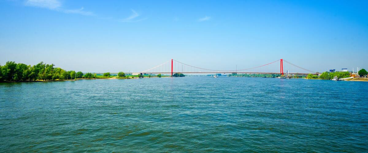 A river with a red bridge spanning across it.