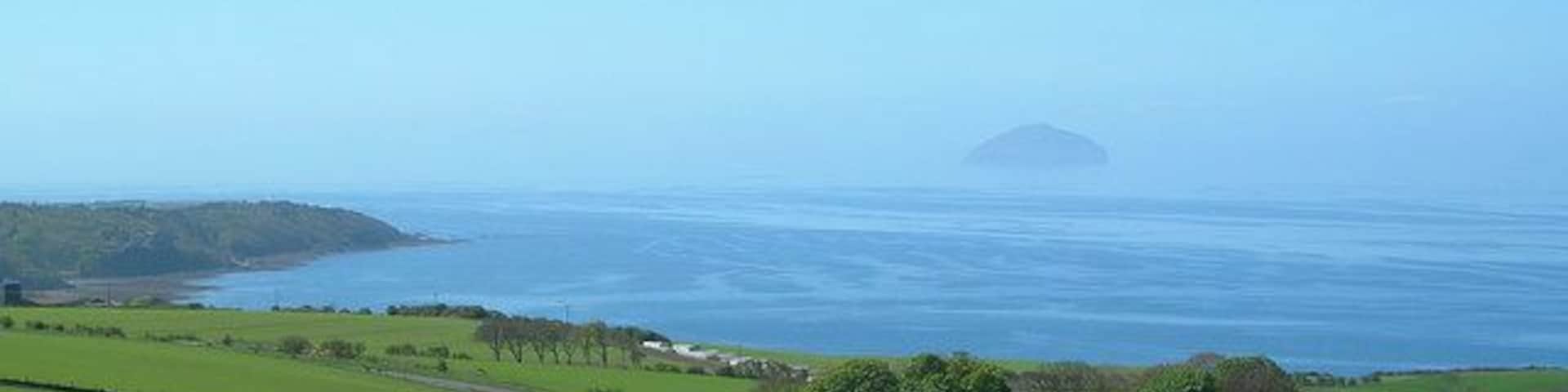 From Knoweside Farm Looking across the Firth of Clyde from Knoweside Farm's barley field on a beautiful April afternoon. The haze had just cleared sufficiently to get a good view of Ailsa Craig.
